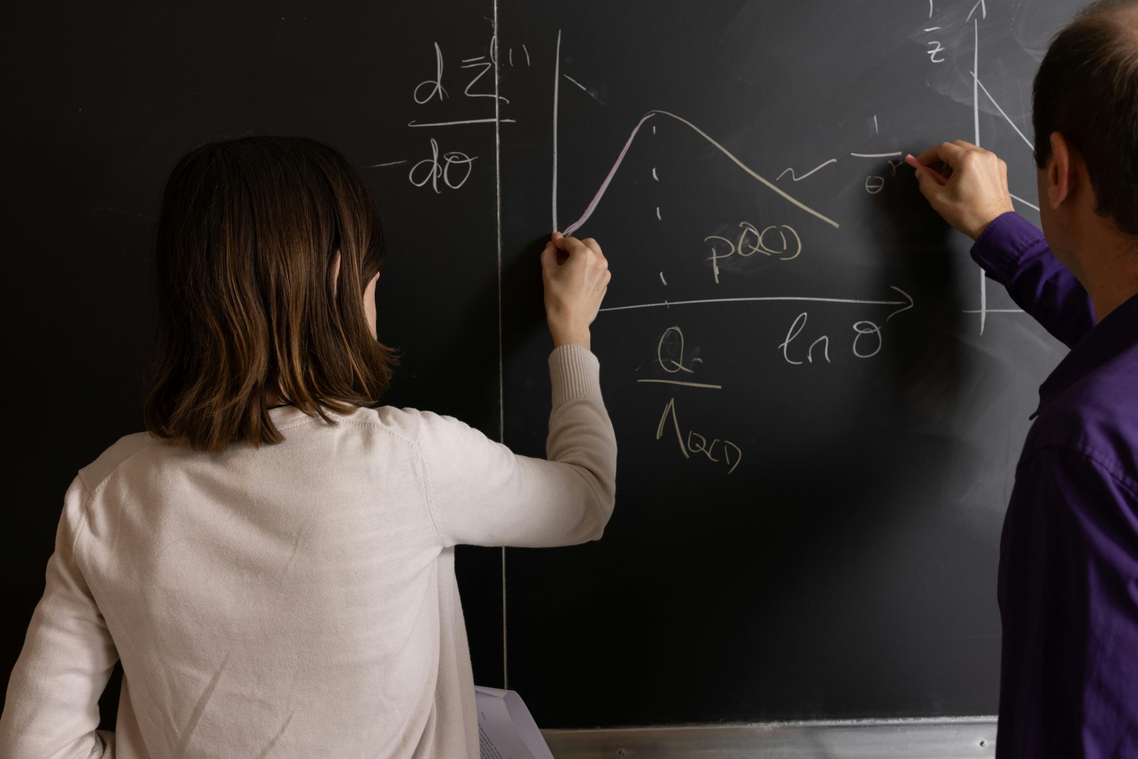 Students and educators working on mathematics at a blackboard